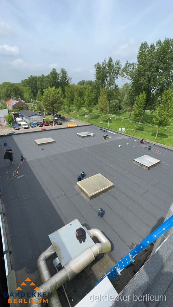 Dakdekker aan het werk op groot plat dak met bitumen in Berlicum Dakdekker aan het werk op groot plat dak met bitumen in Berlicum
